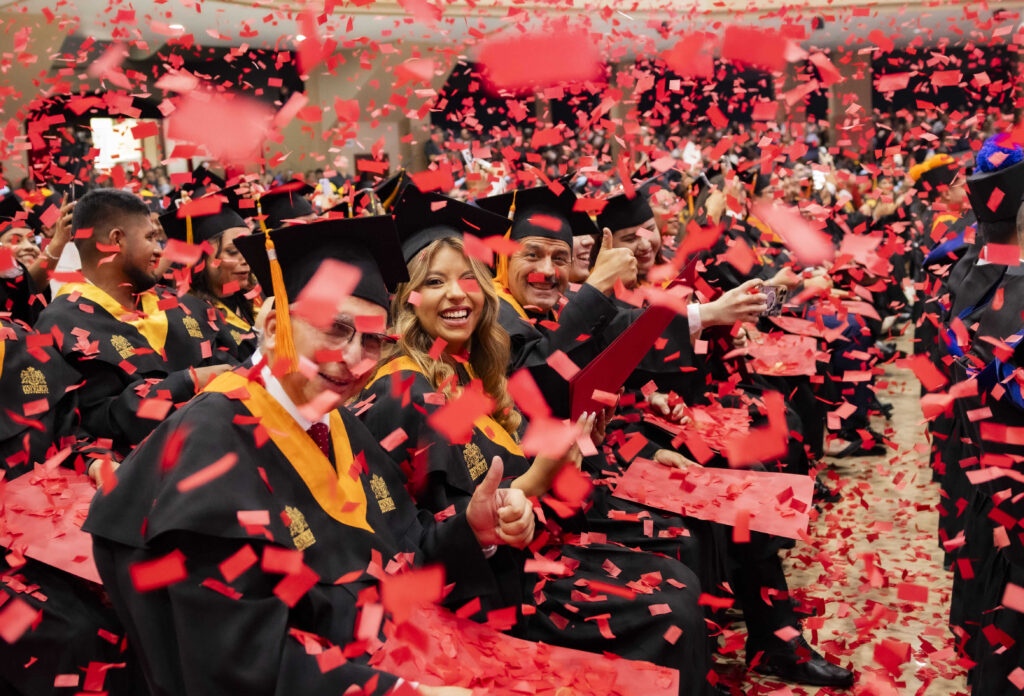 Graduados de la Universidad San Pablo de Guatemala celebran con confeti rojo tras culminar la promoción 2026"