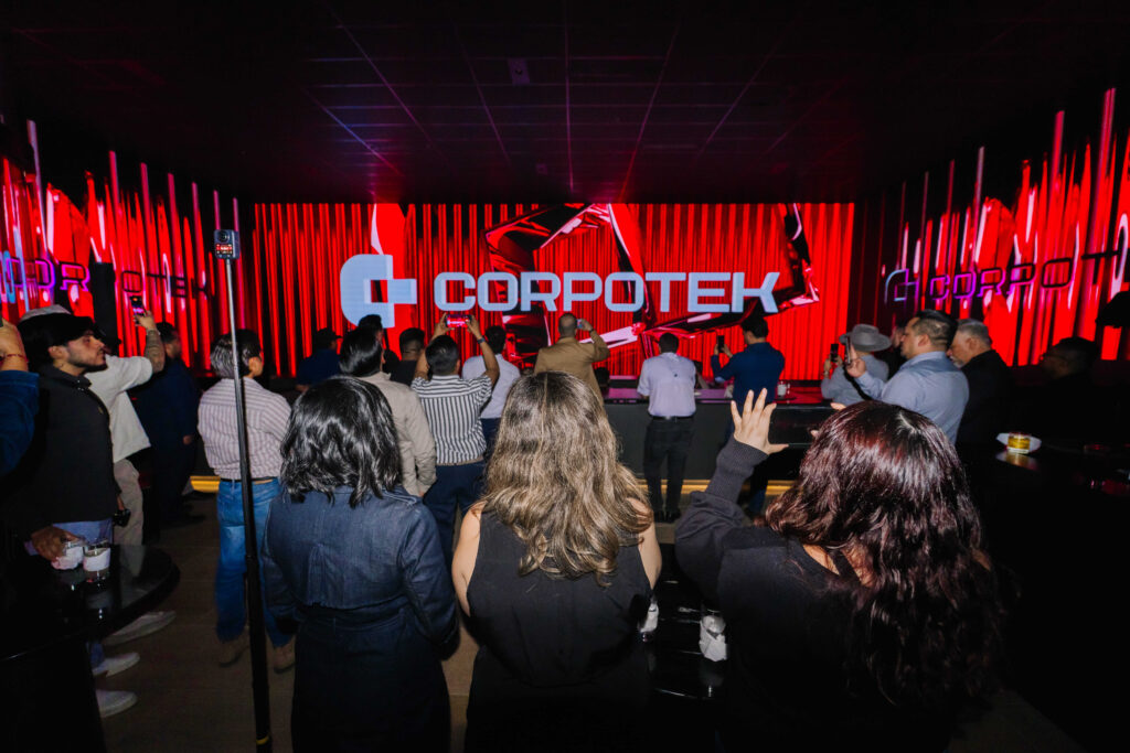 Asistentes graban con celular el logo de Corpotek en pantalla LED durante presentación de Francisco Reyes, CEO de la empresa, en el LED Summit