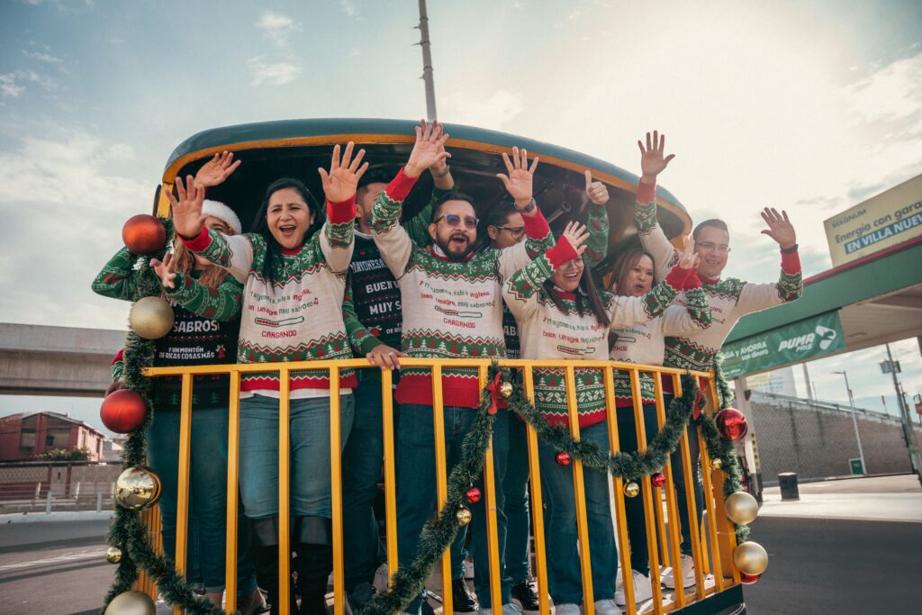 Equipo de B&B celebra los 60 años del jingle navideño en un bus decorado con la leyenda '60 años Iniciando Navidad